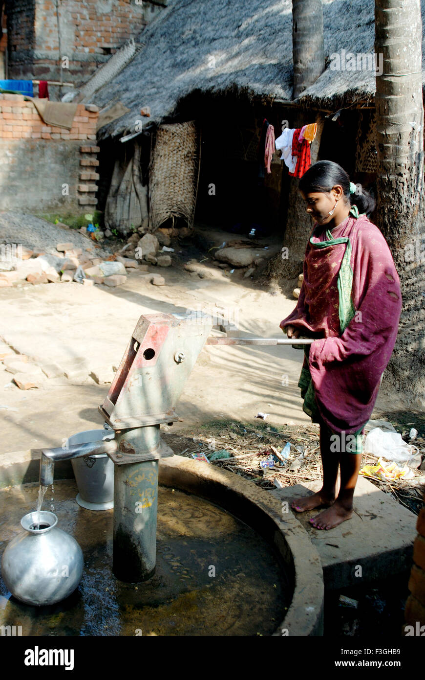 Woman using hand pump for drinking water ; Bhubaneswar ; Orissa ; India