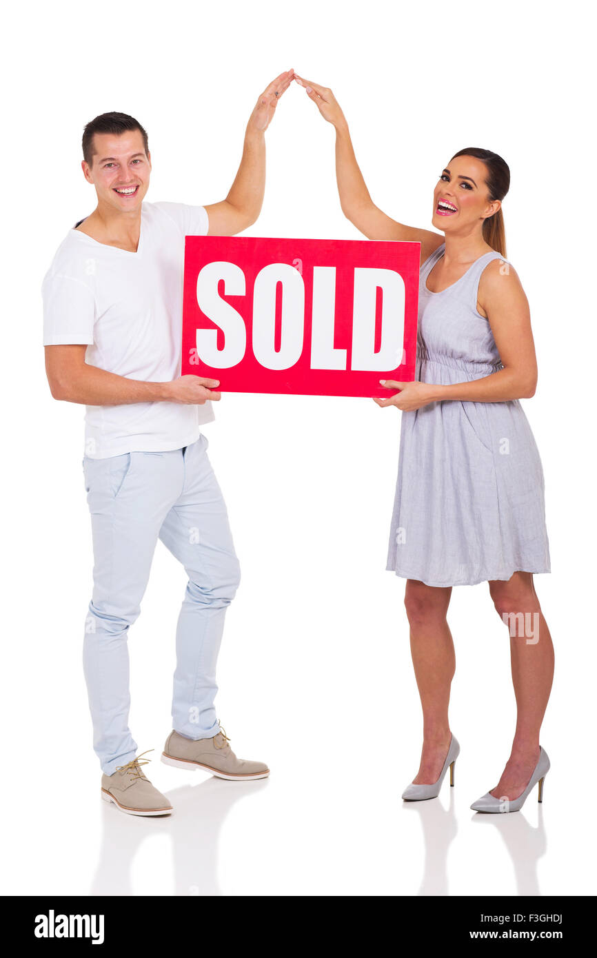 cheerful couple holding sold sign for house Stock Photo - Alamy