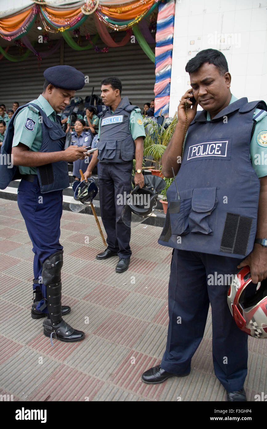 Police force ; policemen talking on mobile wearing blue color uniform ; Dhaka ; Bangladesh Stock Photo