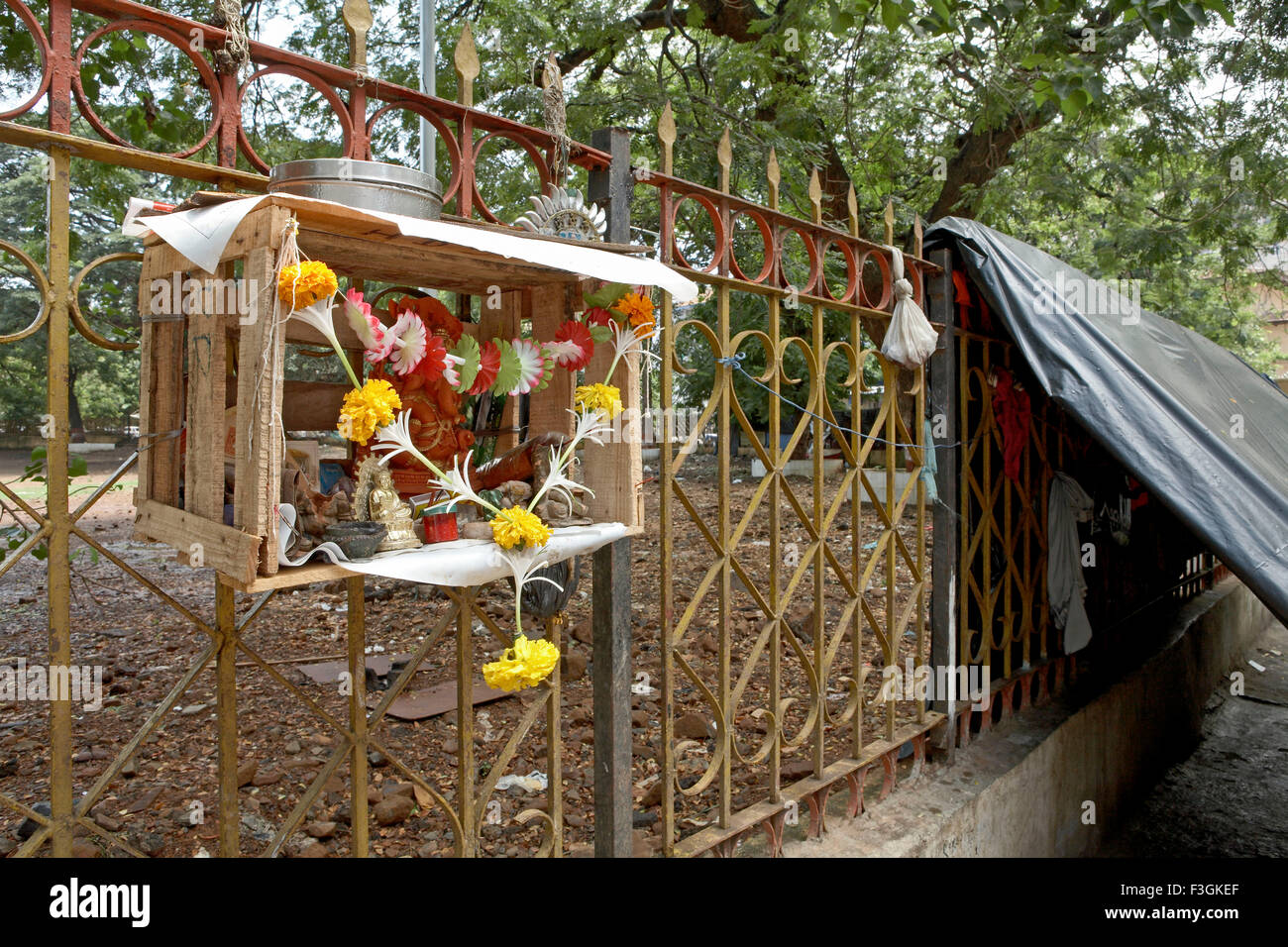 shrine in a wooden box hung on the fence of a playground ensures cleanliness surrounding Mumbai Bombay Stock Photo
