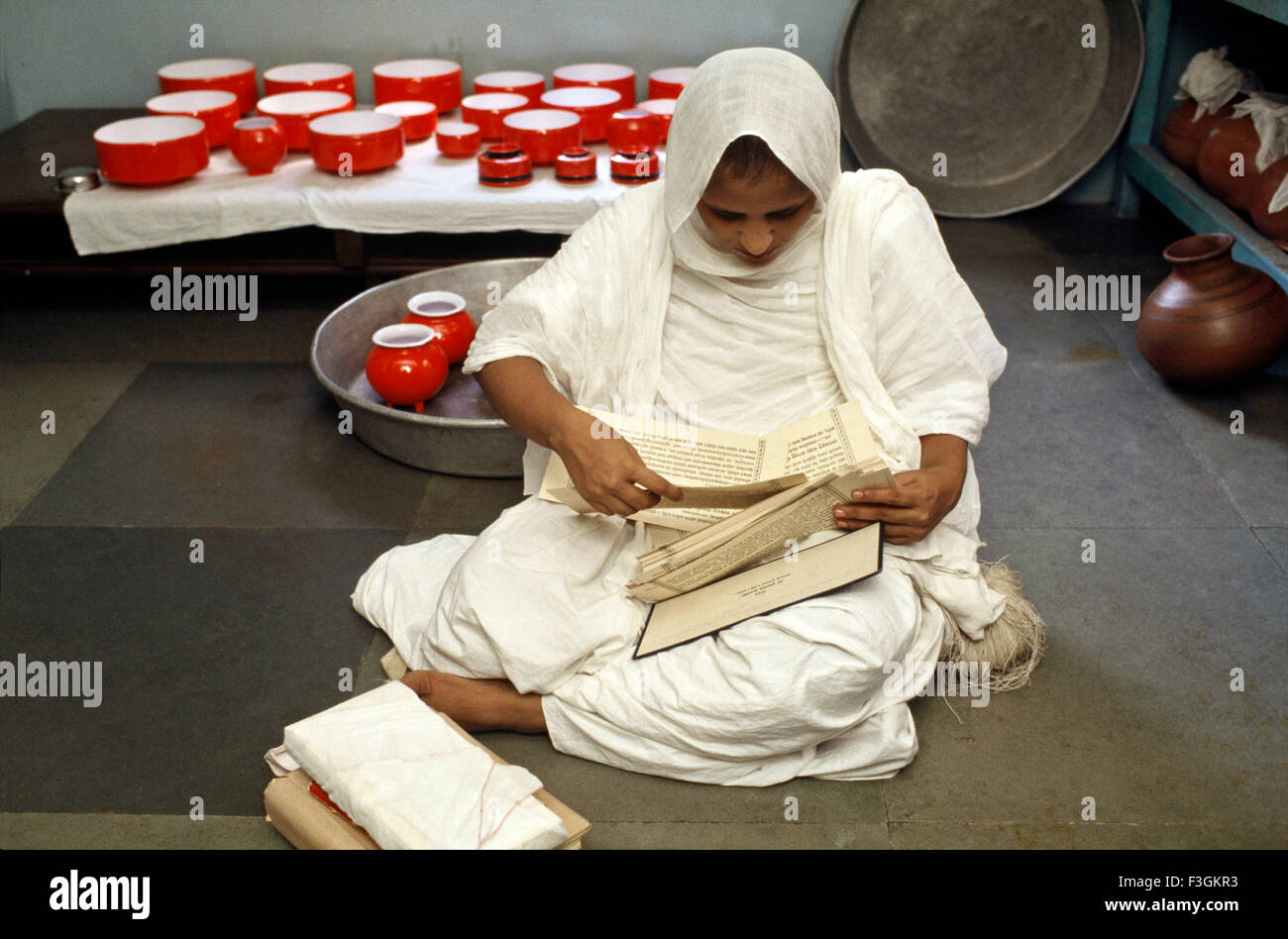 Jain nun wearing unstitched white robes studying Jain scriptures in Bombay now Mumbai Maharashtra India Stock Photo