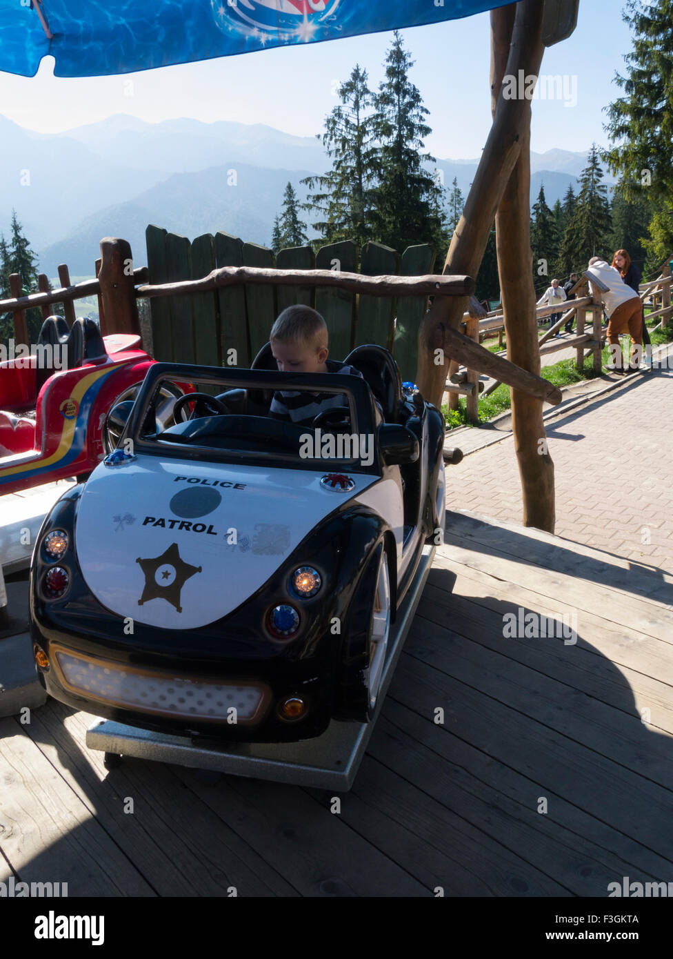 Young boy in a toy police patrol car Zakopane Poland popular tourist resort in Southern Poland on a lovely autumn September day vertical orientation Stock Photo