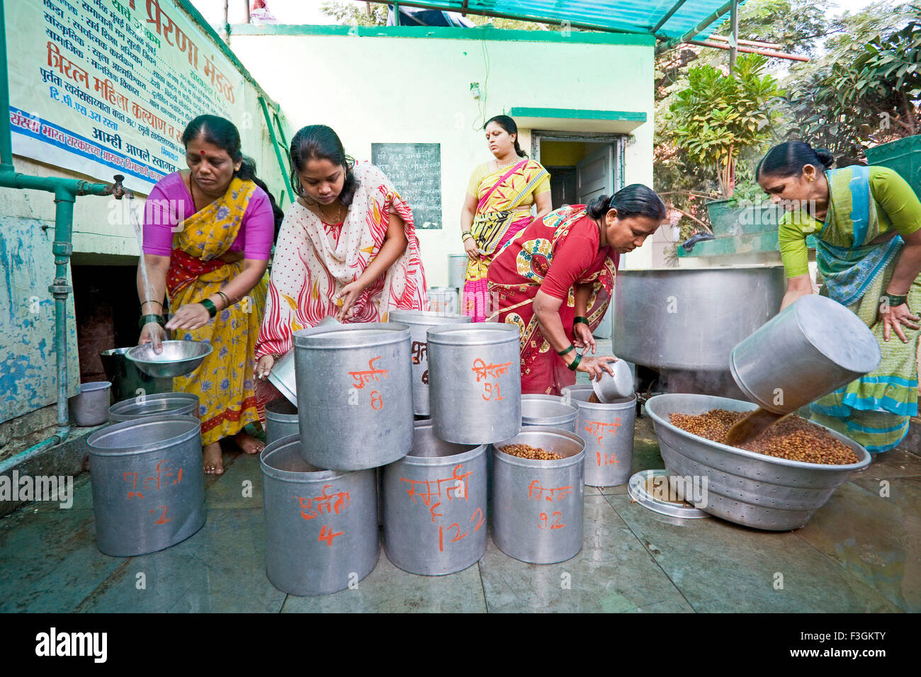 Women employees cook food for children as a part of Government's school mid day meal scheme ; Mumbai ; Maharashtra Stock Photo