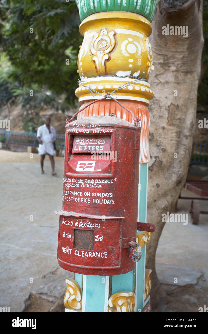 Red Letter box of Indian Post hung on a decorative pillar at Sri Kalahasti ; Andhra Pradesh ; India Stock Photo
