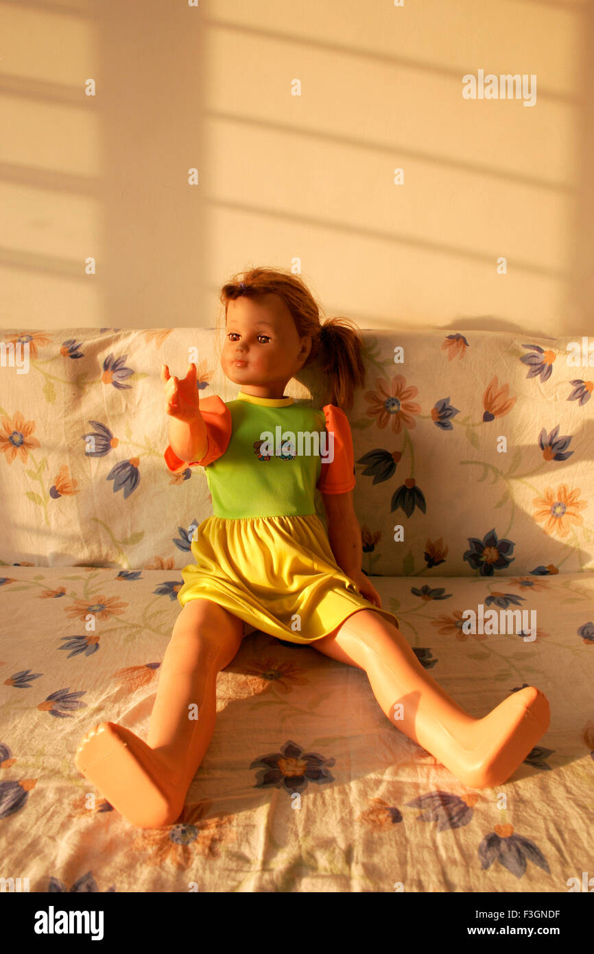 Doll made of rubber plastic with outstretched right arm appearing to relaxing in early morning warm light ; Pune Stock Photo