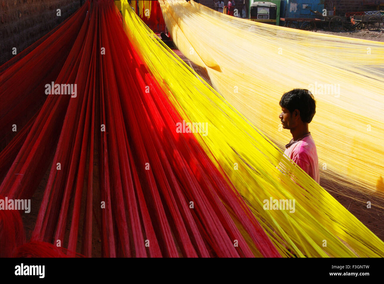 Man drying silky threads for making silky garlands Stock Photo