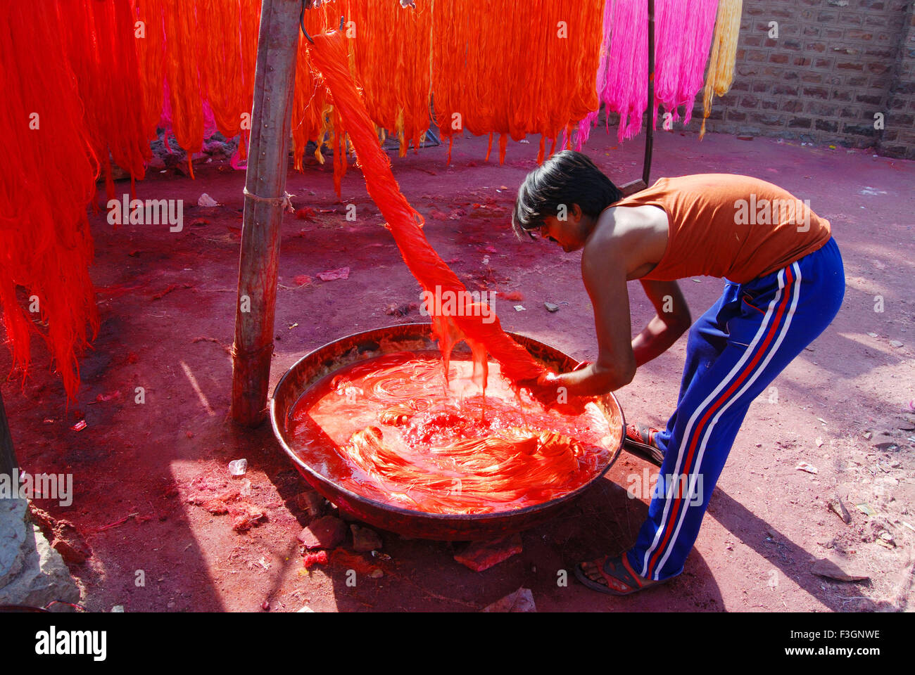 Man dyeing silky thread in color for making silky garland Stock Photo ...