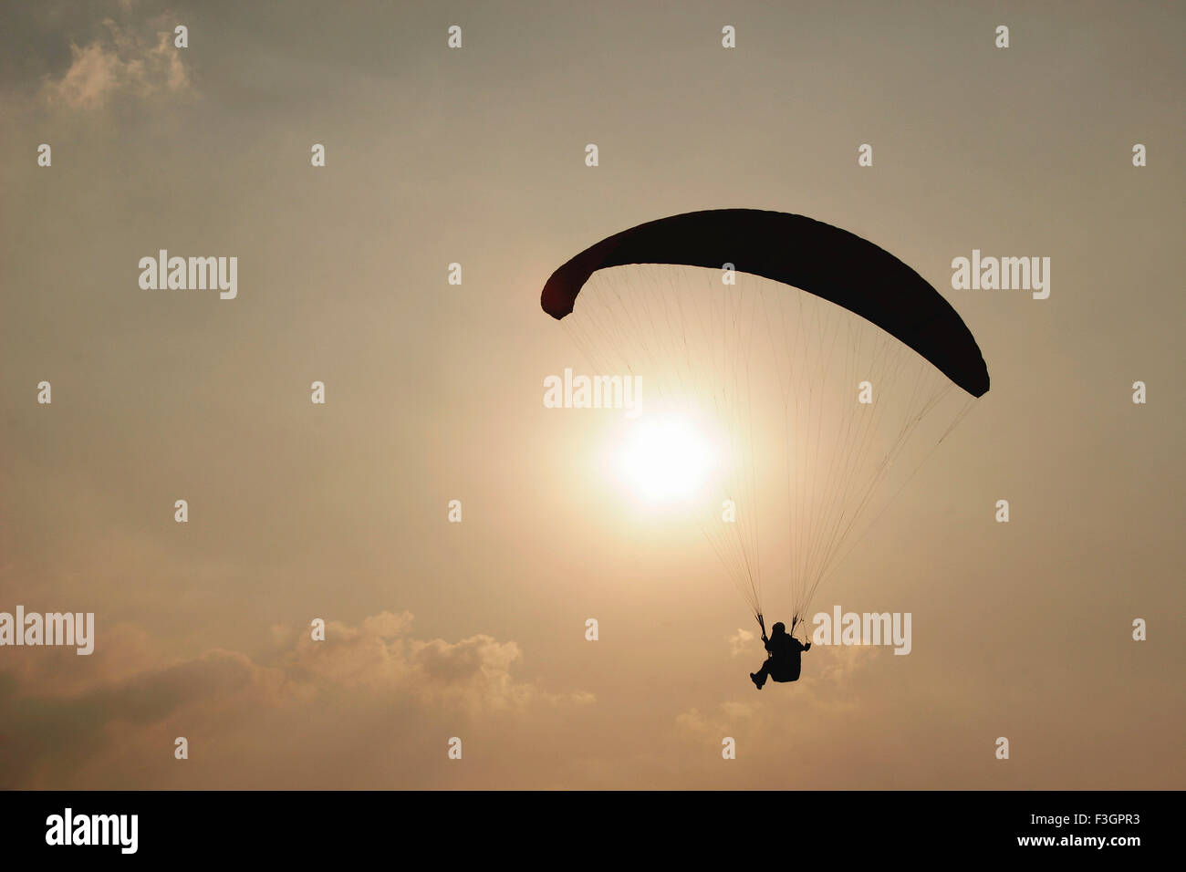 Paraglider enjoying against setting sun ; Panchgani ; Maharashtra ; India Stock Photo