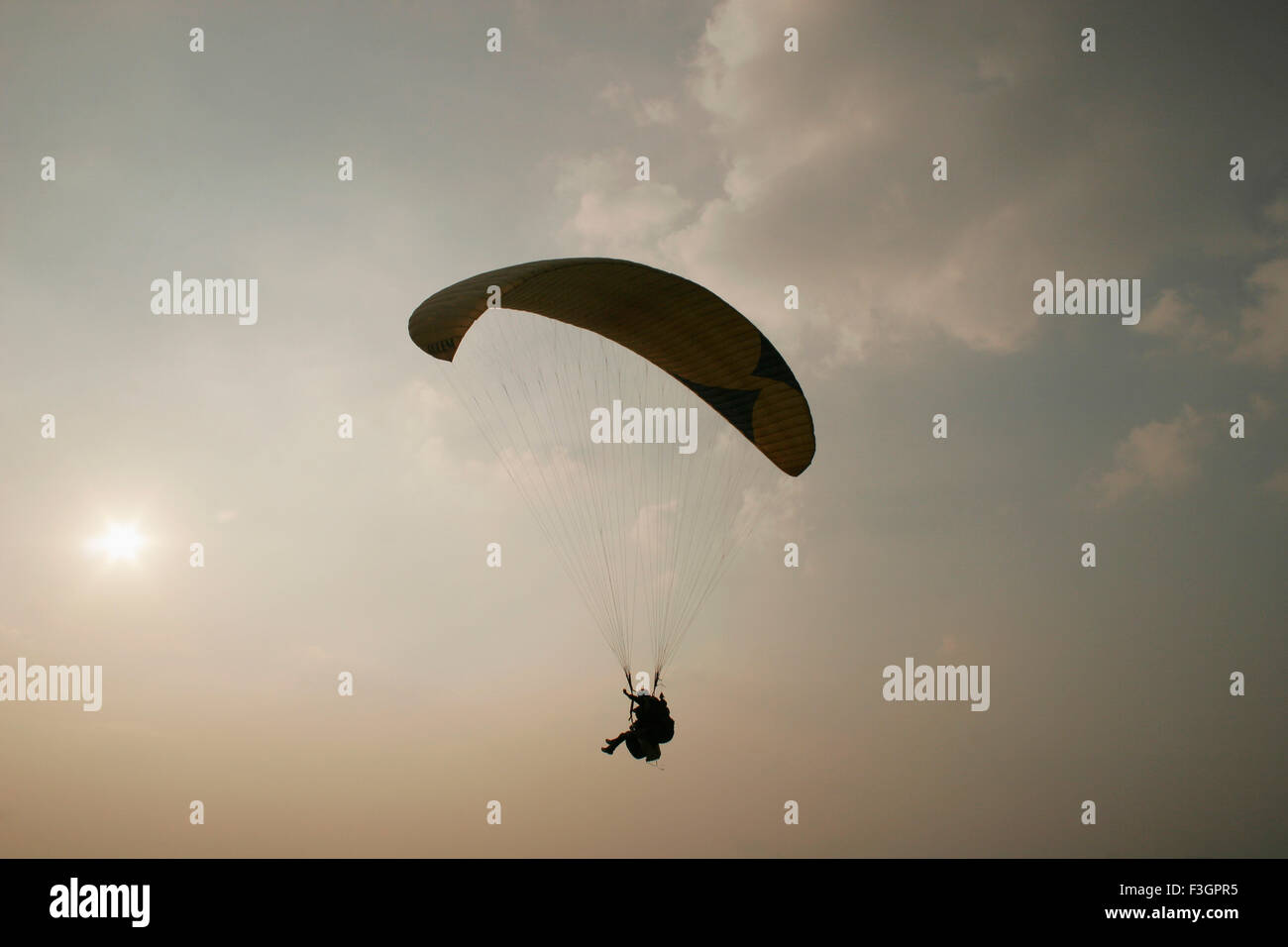 Paraglider enjoying against setting sun ; Panchgani ; Maharashtra ; India Stock Photo