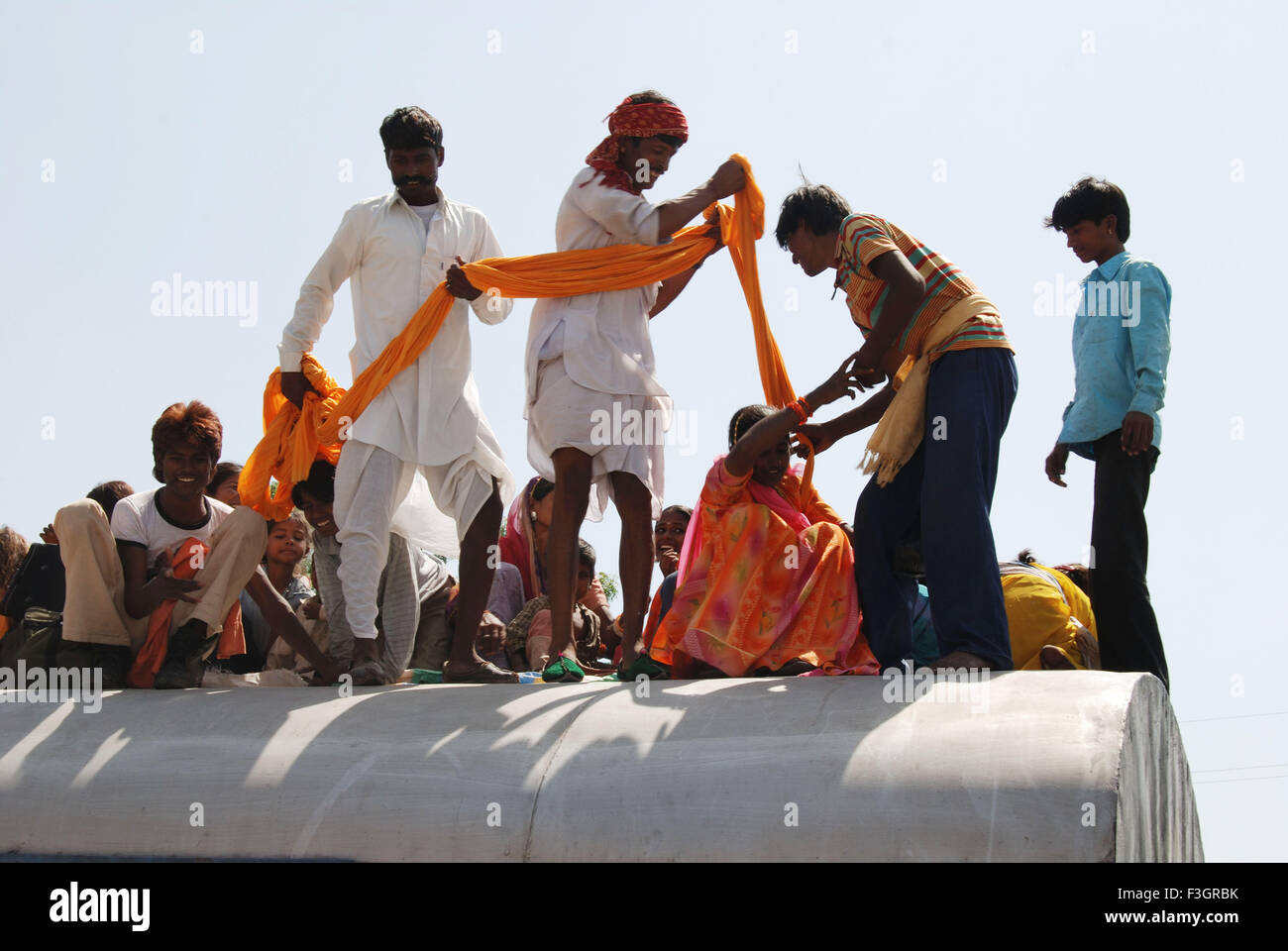 Men successfully dragged woman on roof of train on railway station ; Jodhpur ; Rajasthan ; India Stock Photo