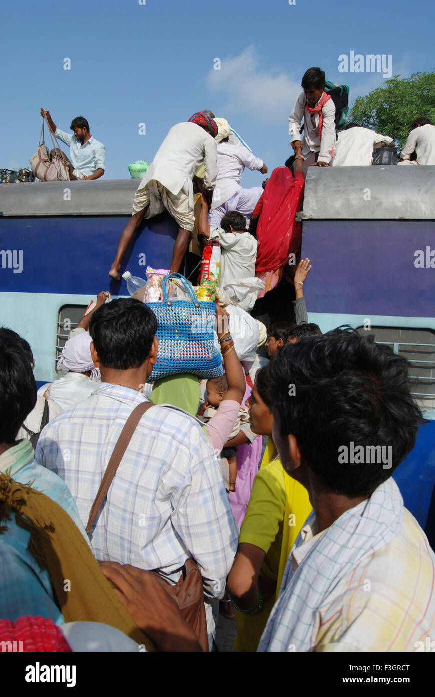 Many people trying to climb on roof of train on railway station ; Jodhpur ; Rajasthan ; India Stock Photo