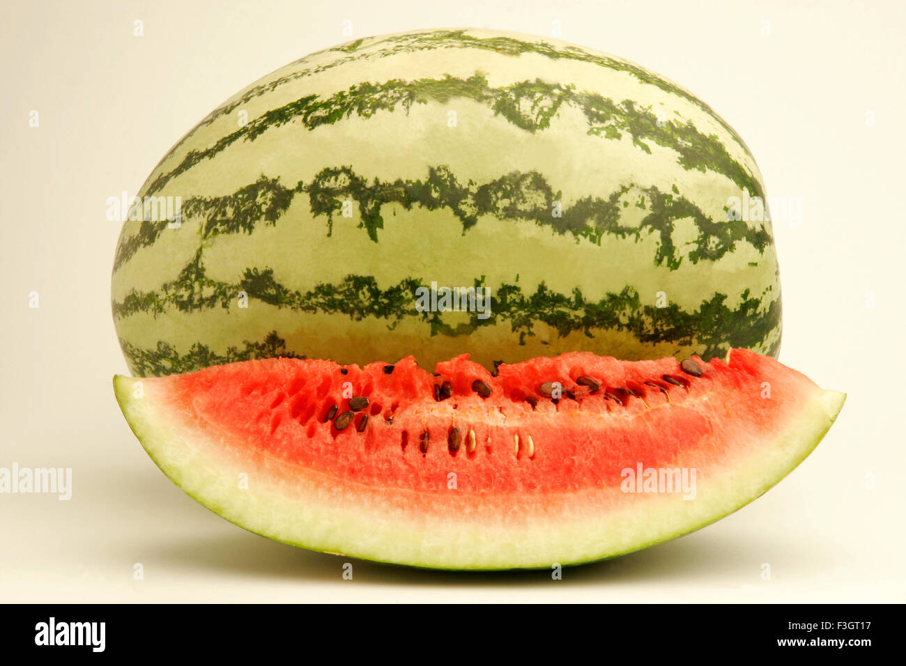 Fruits One full watermelon light dark green stripes one cut slice
