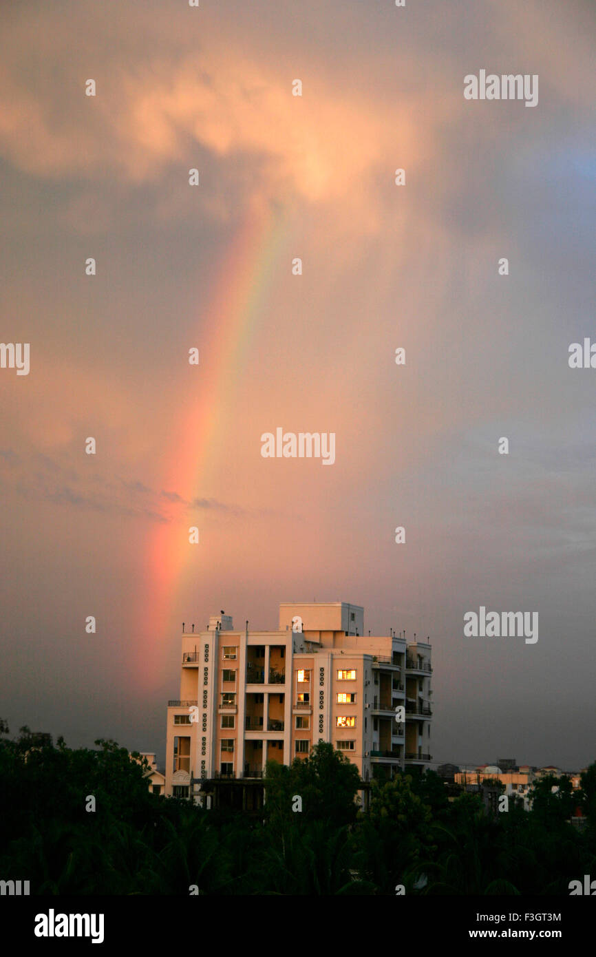 Rainbow and residential building in stormy conditions in evening light ; Pune ; Maharashtra ; India Stock Photo