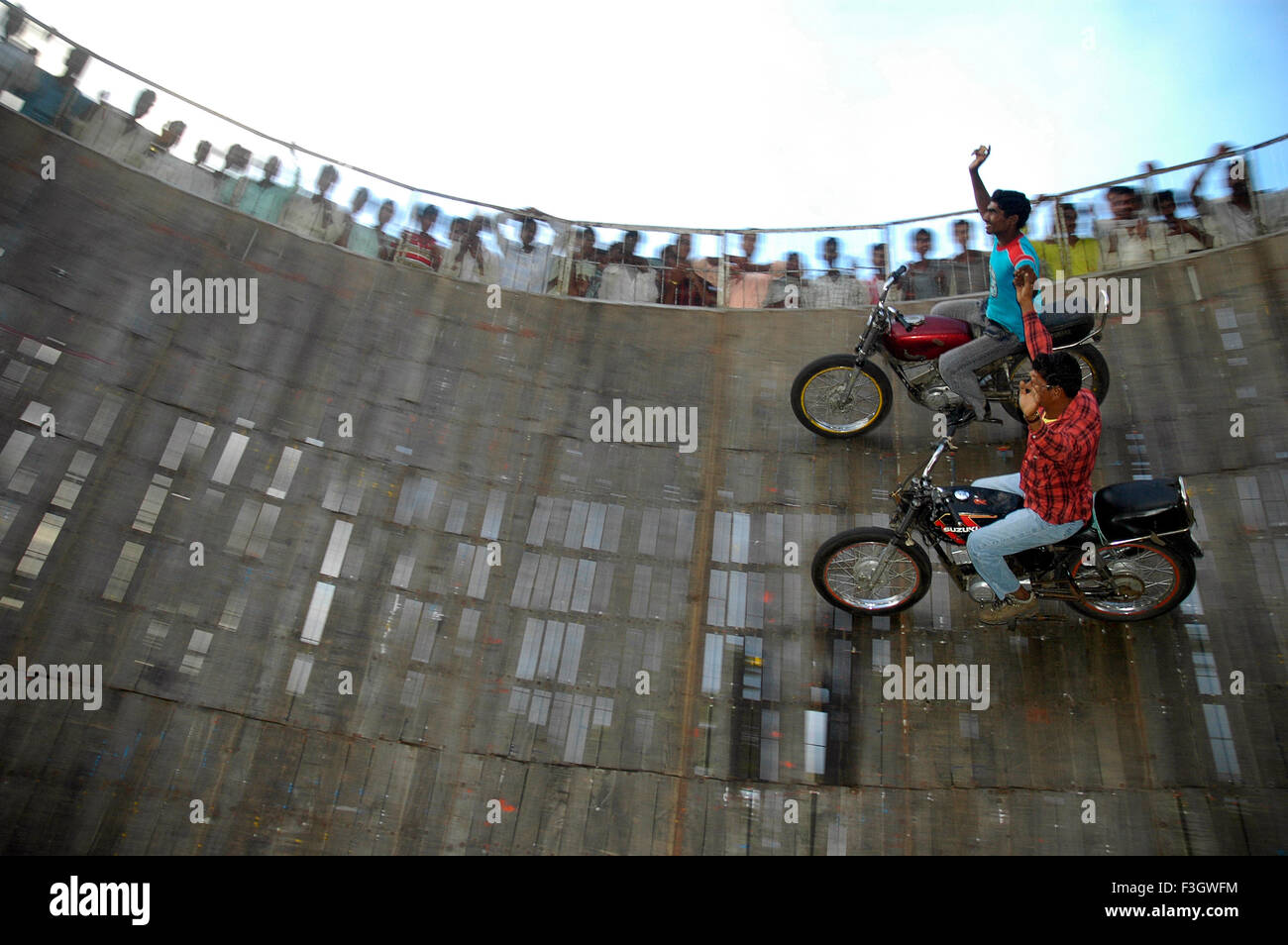 Two dare devil performers performing on motorbikes in well of death at annual Pandharpur fair; Pandharpur Stock Photo