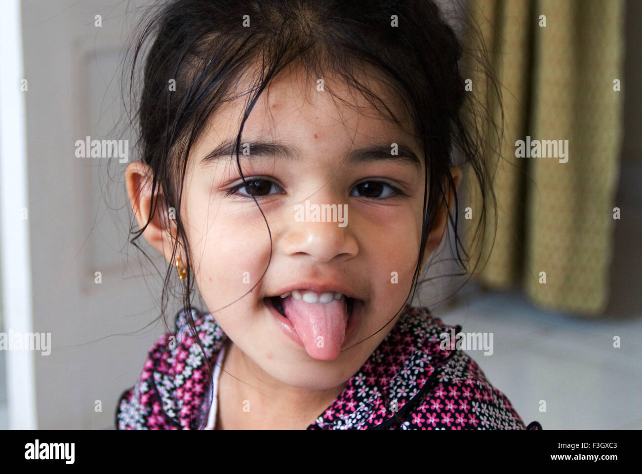 Four years old girl in playing mood showing her tongue MR#556 Stock Photo