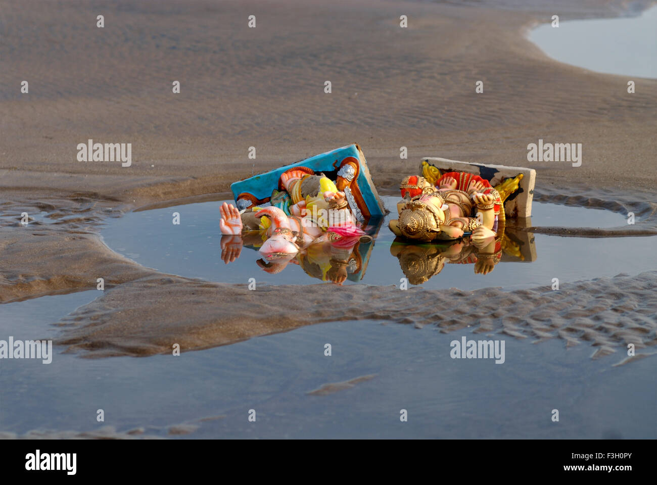 Ganesh idols lying in polluted water after immersion on Aksa beach ; Bombay Mumbai ; Maharashtra ; India Stock Photo