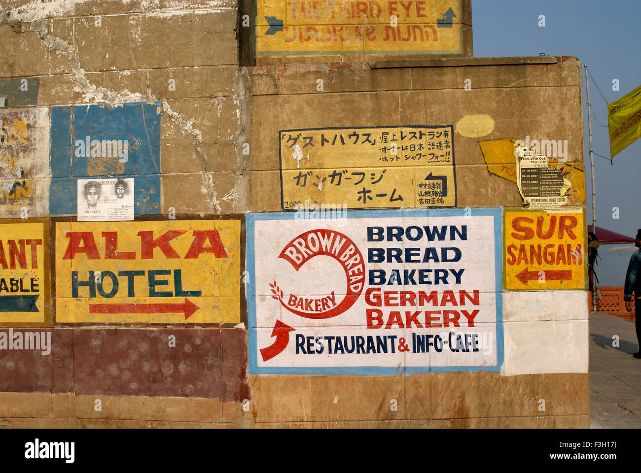 Directions for restaurants and hotels painted in English and Chinese script on wall ; Varanasi ; Uttar Pradesh ; India Stock Photo