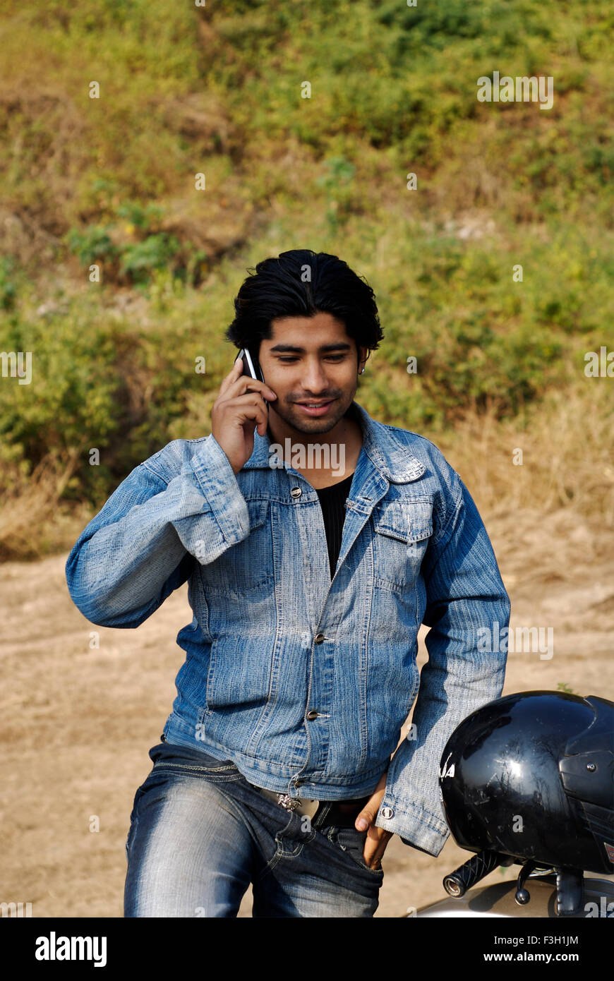 A young male talking on mobile phone ; Dehradun ; Uttaranchal ; India Stock Photo