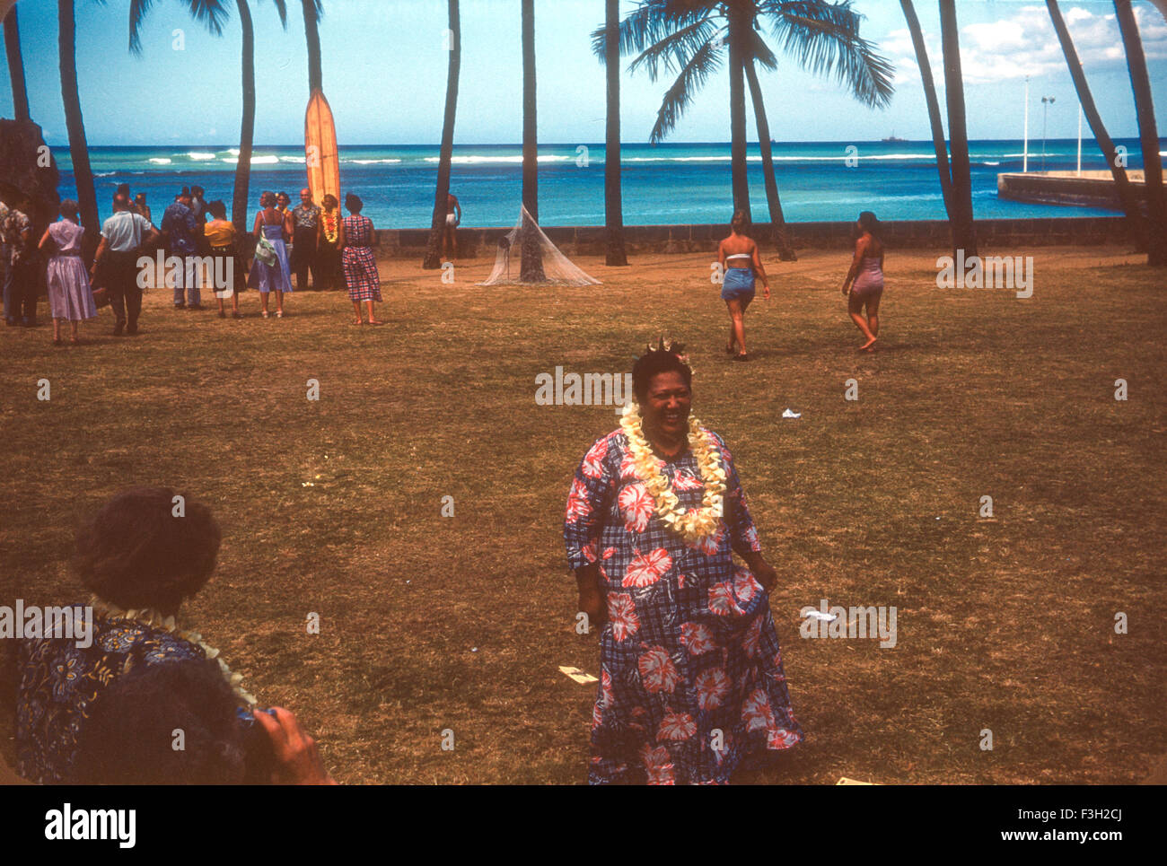 Tourists attend a luau in Hawaii during the 1950s with entertainment by