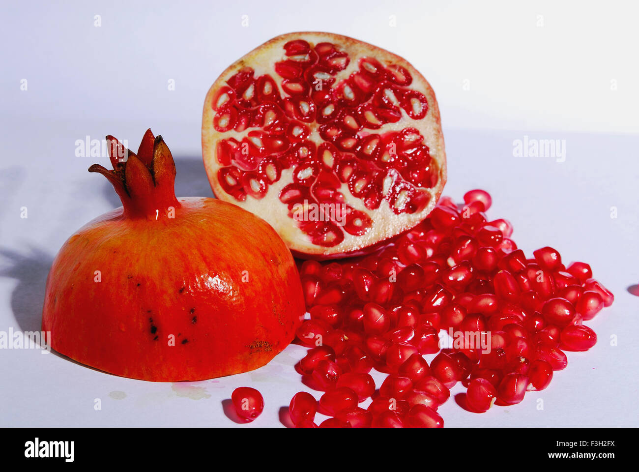 Fruits ; one cut Pomegranate with seeds on white background Stock Photo