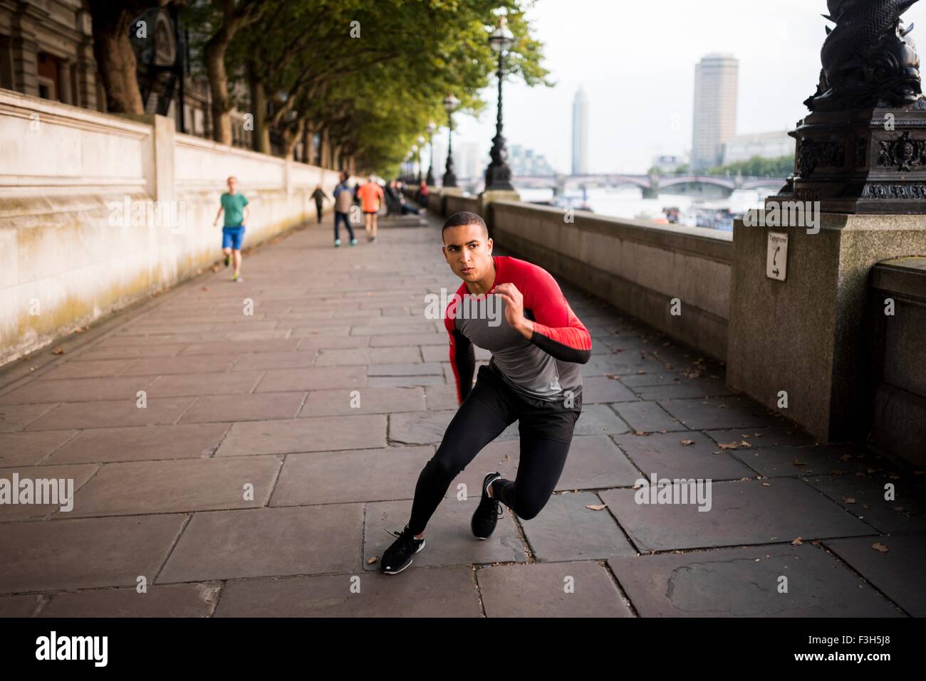 Young man speed training along riverbank Stock Photo