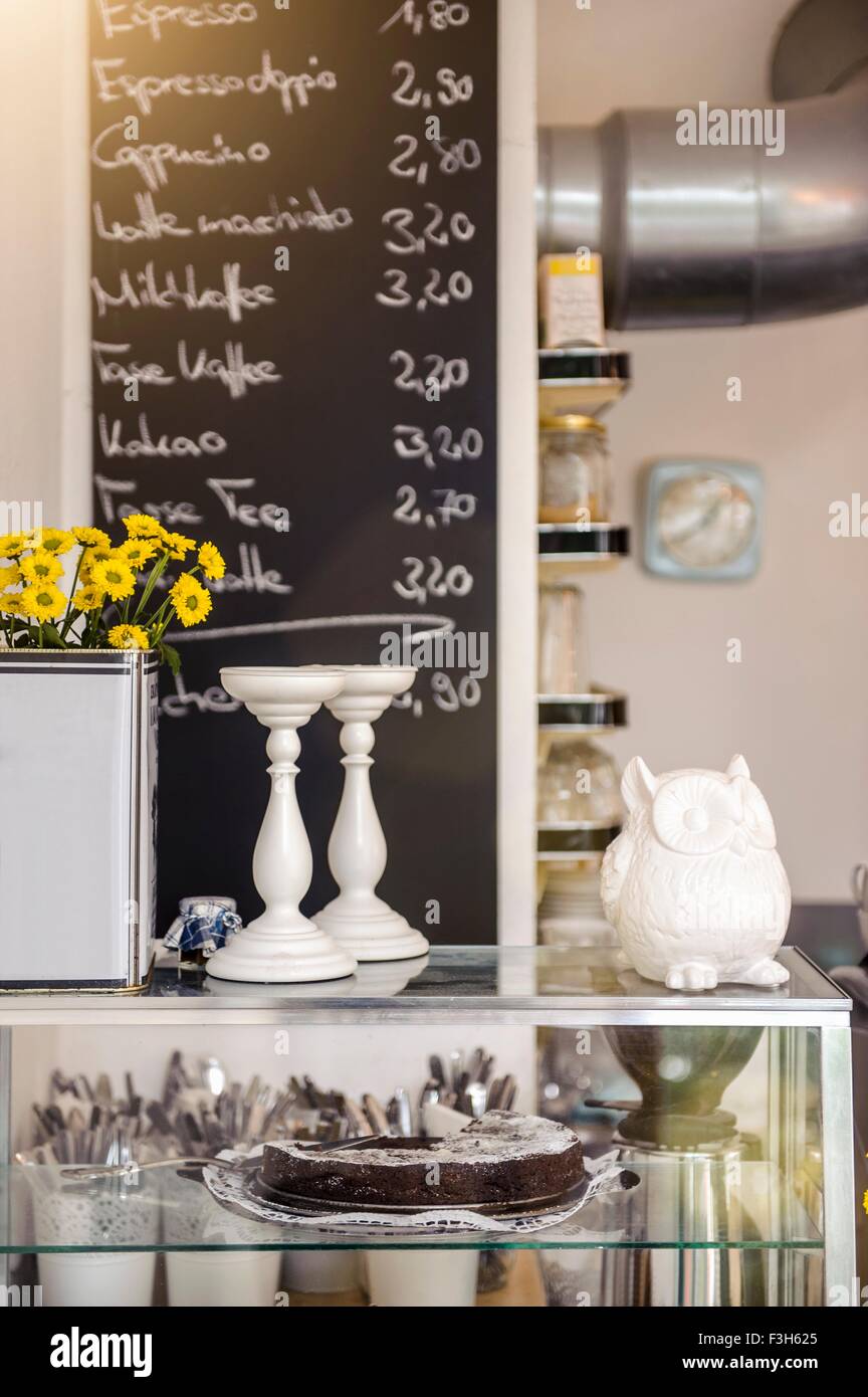 Cafe display cabinet in front of chalkboard menu Stock Photo - Alamy