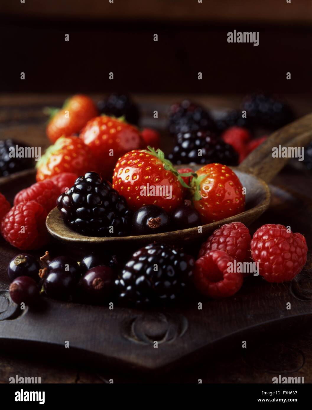 Still life of strawberries, raspberries and blackberries on spoon Stock Photo