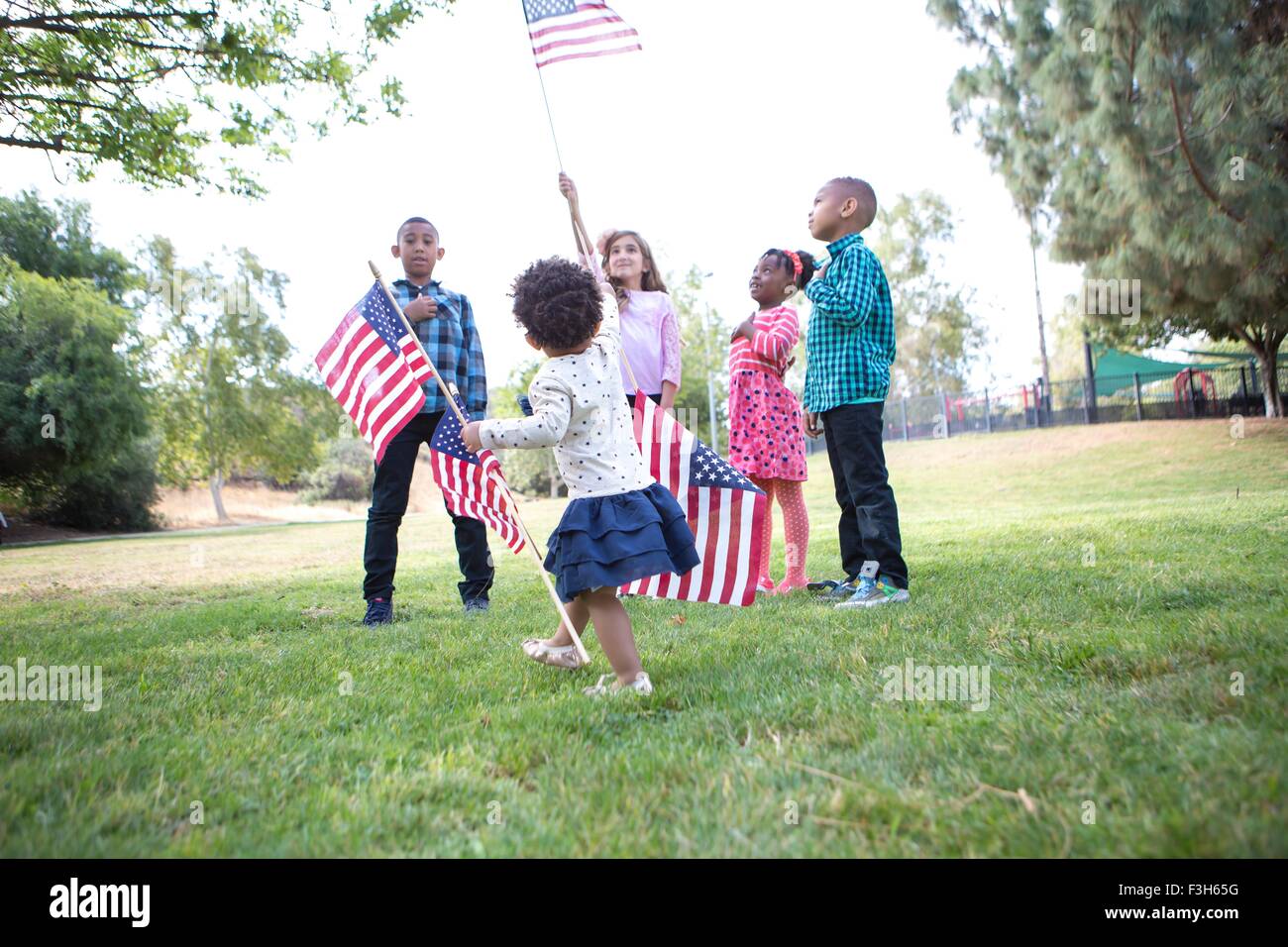 Children holding up American flags in park Stock Photo