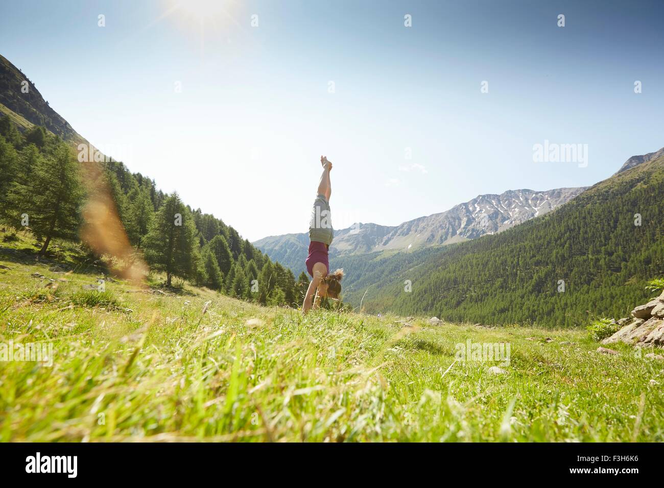 Young woman doing handstand, Val Senales, South Tyrol, Italy Stock Photo