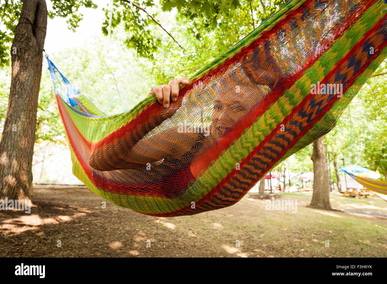 Portrait of mid adult woman lying in park hammock Stock Photo - Alamy