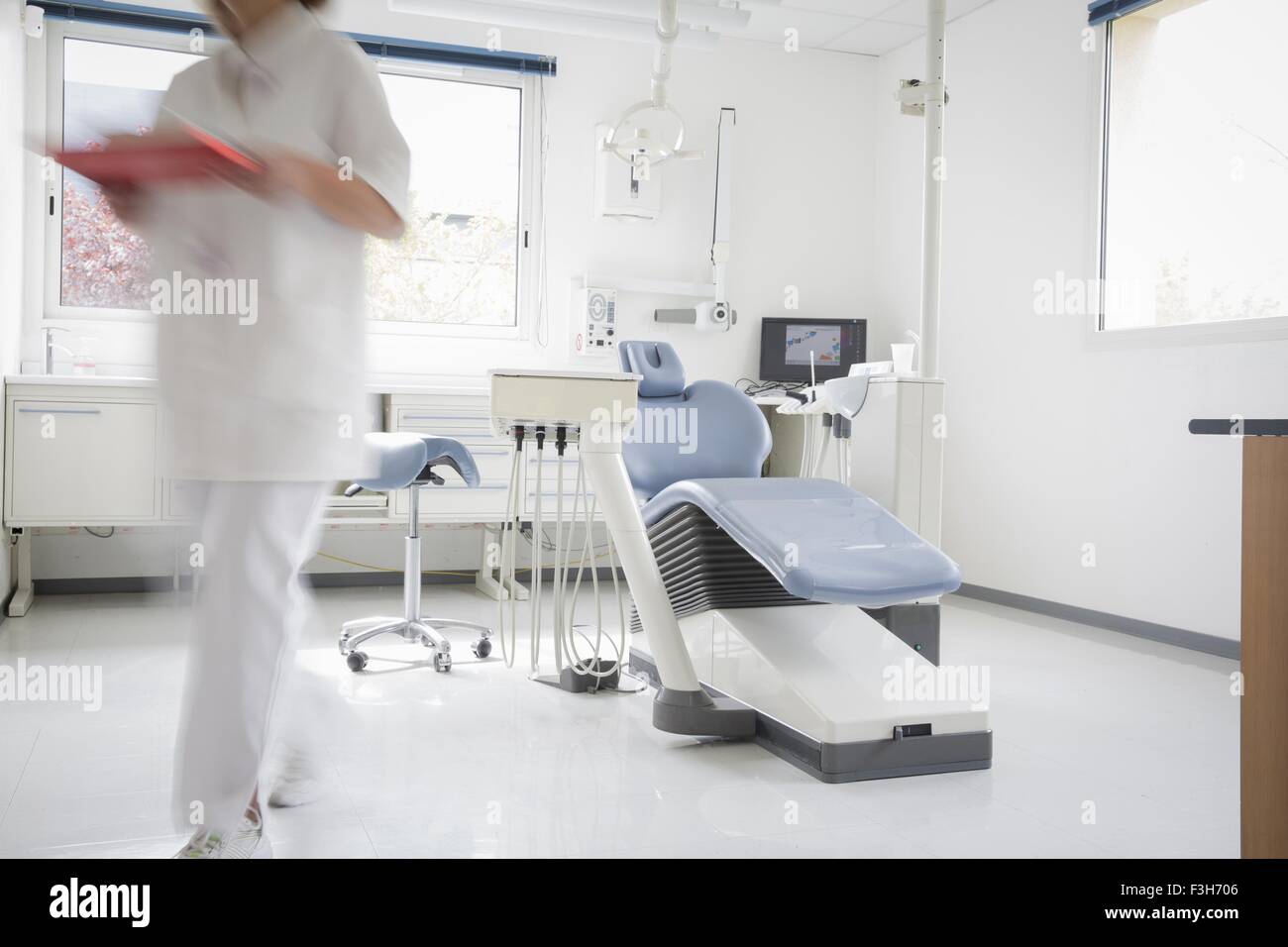 Dentist chair, dental nurse walking away, blurred motion Stock Photo
