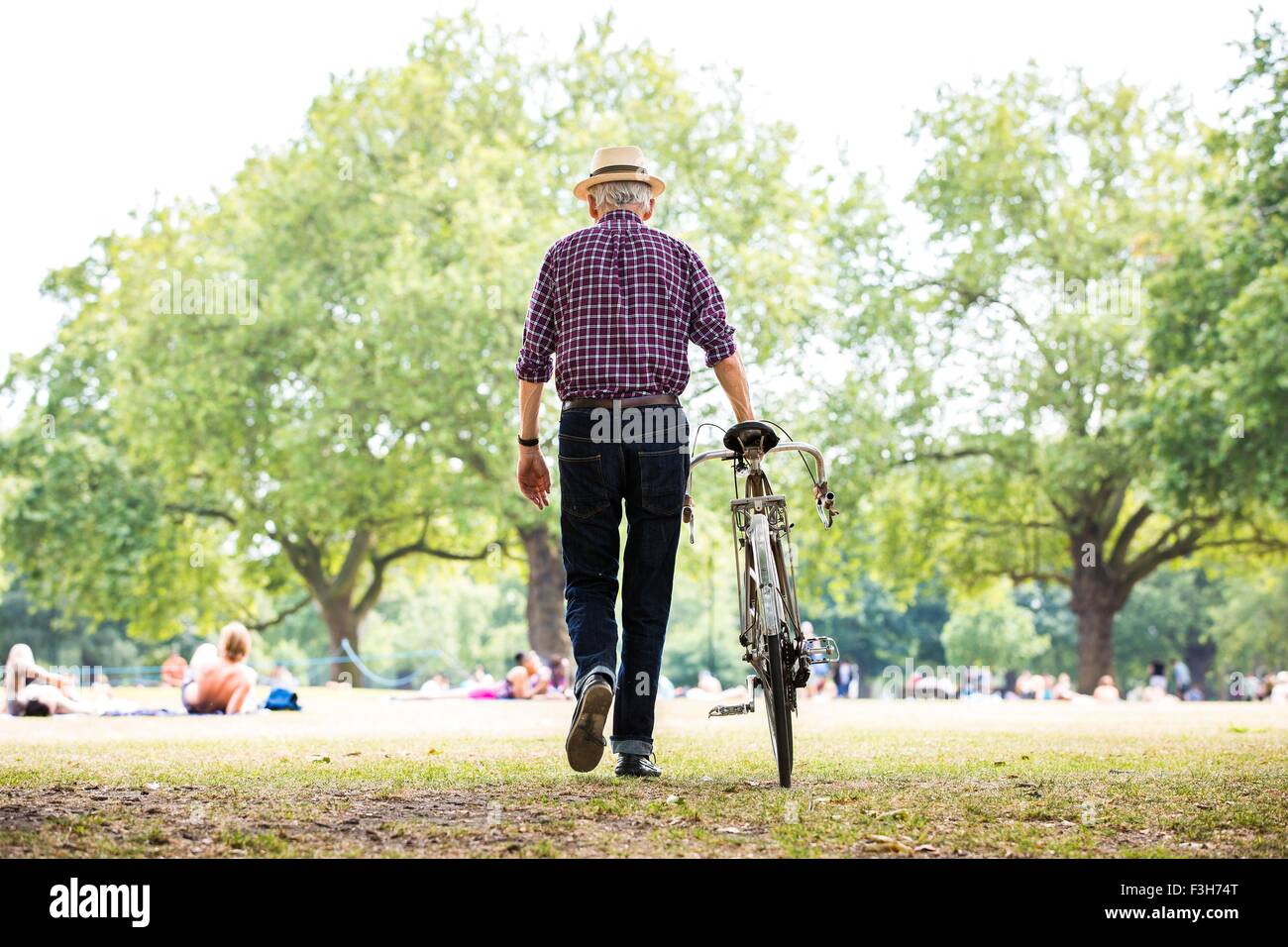 Senior man with bicycle in park, Hackney, London Stock Photo