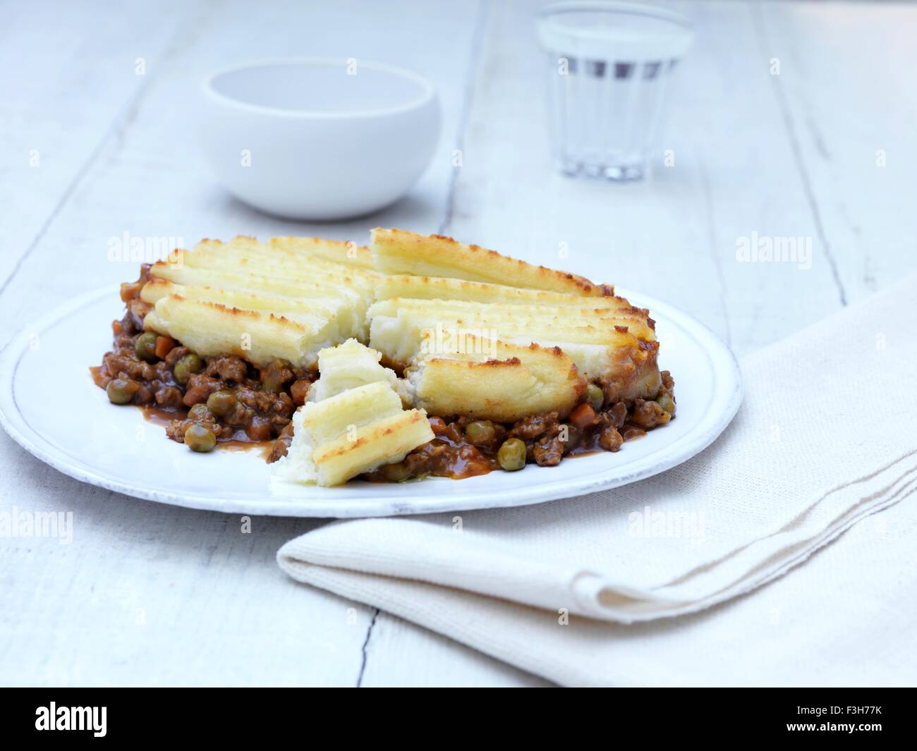 Still life of cottage pie with minced beef, gravy and vegetables on