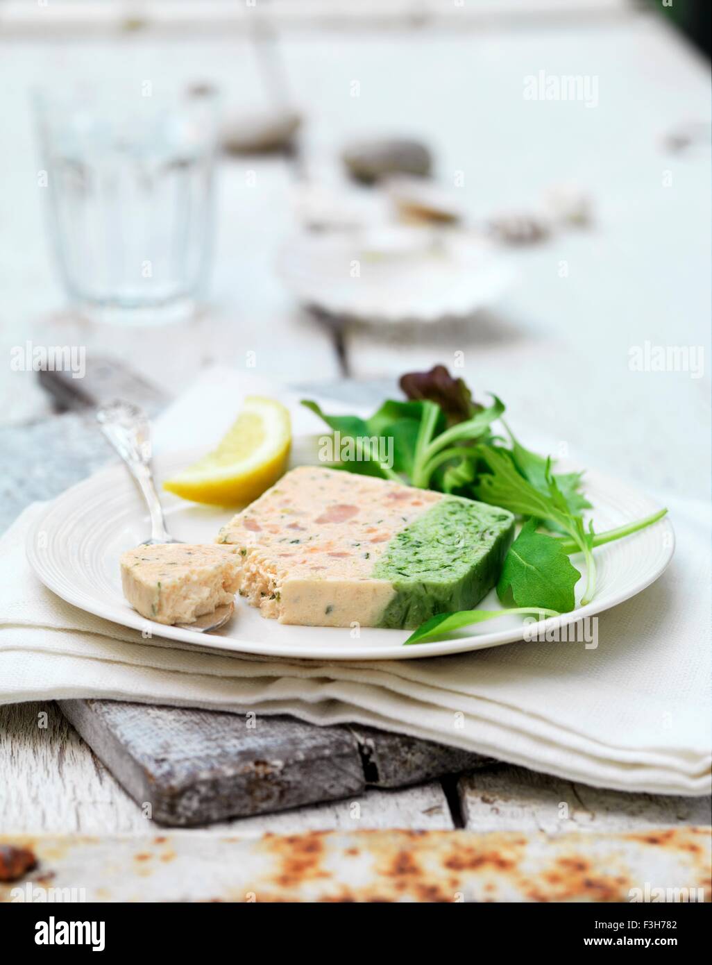 Still life of prawn and asparagus terrine slice and salad leaves with lemon Stock Photo