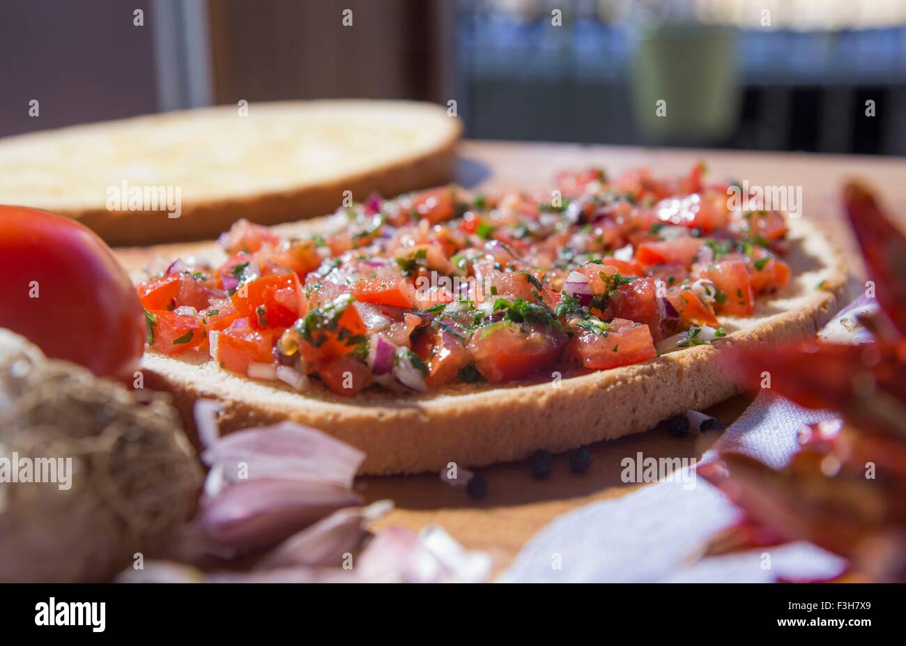 Bread with chopped vegetables and herbs on kitchen counter Stock Photo