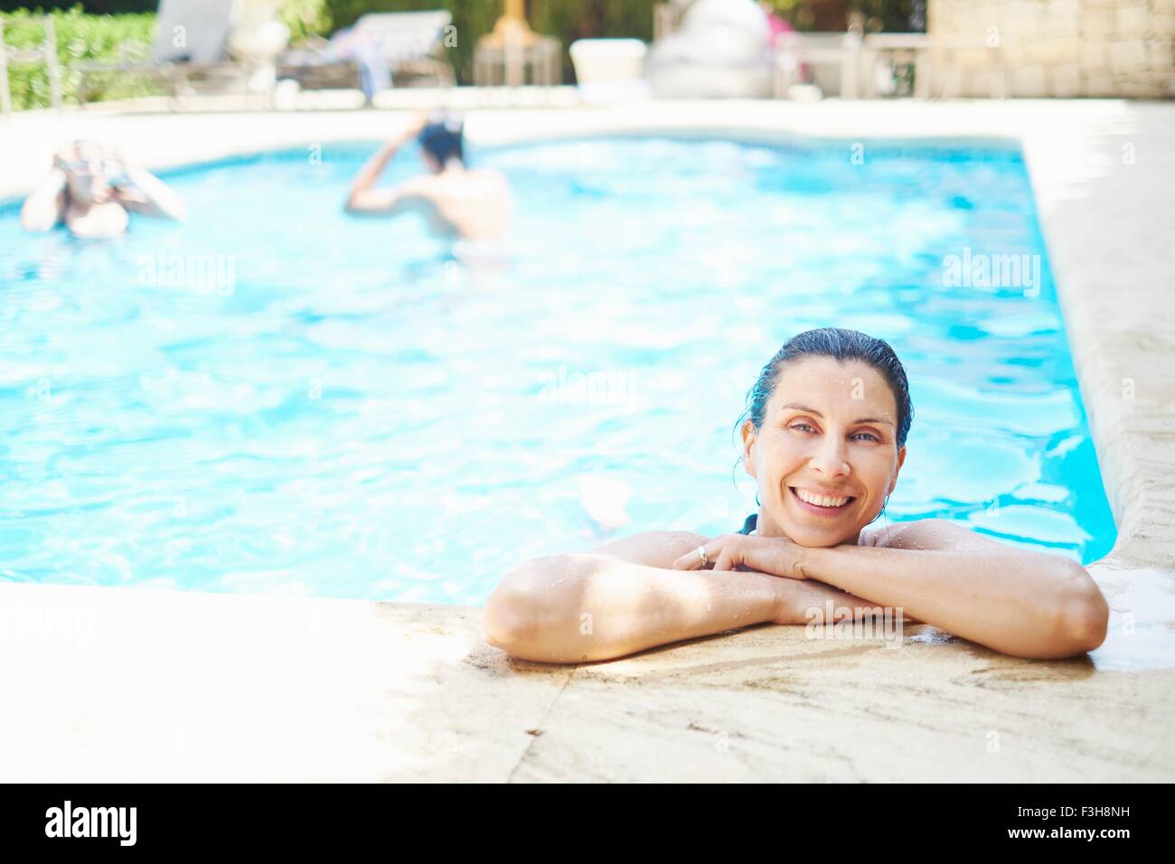 Portrait of smiling mature woman with wet hair in swimming pool Stock Photo