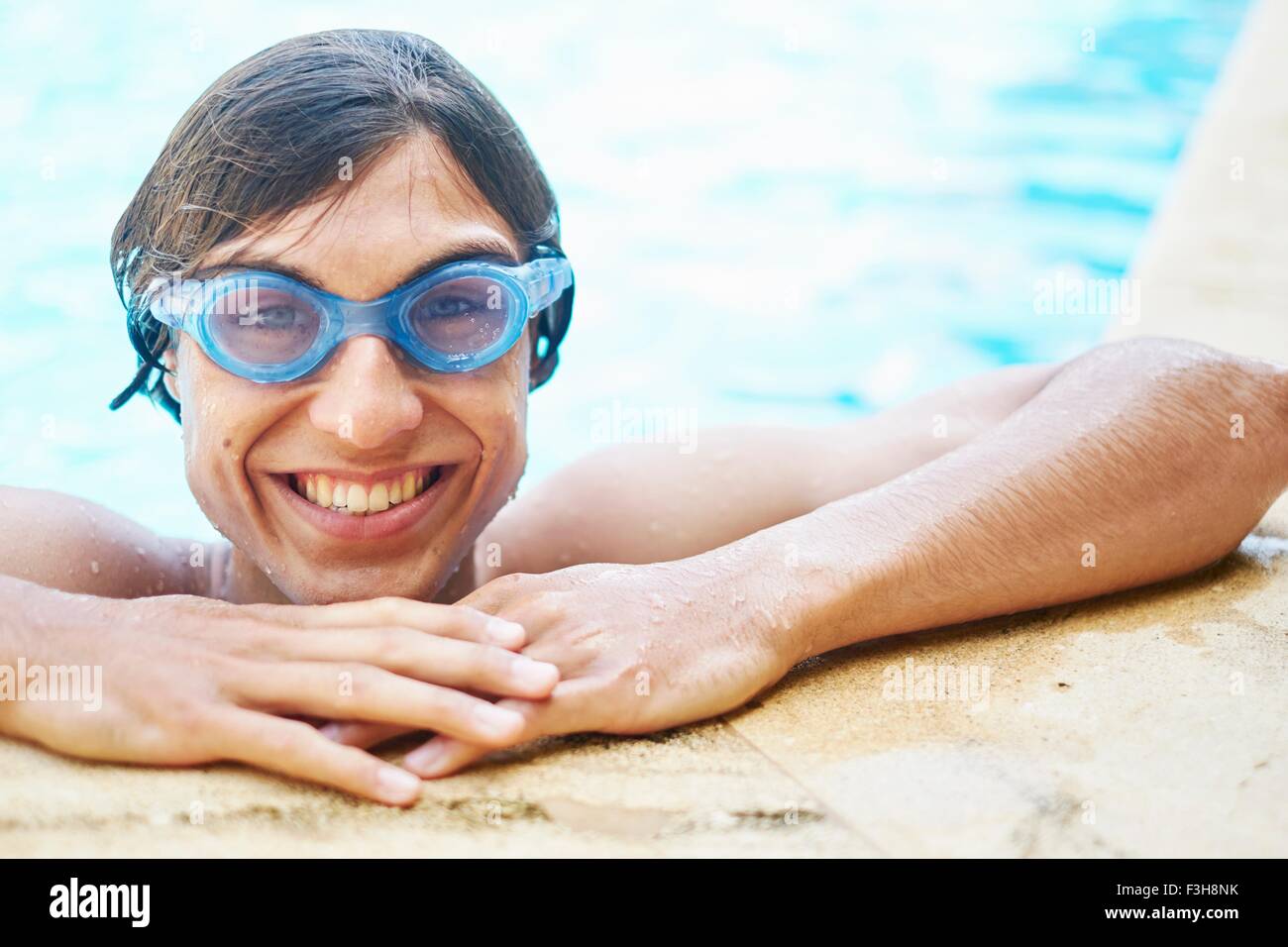 Portrait of young man wearing goggles in swimming pool Stock Photo