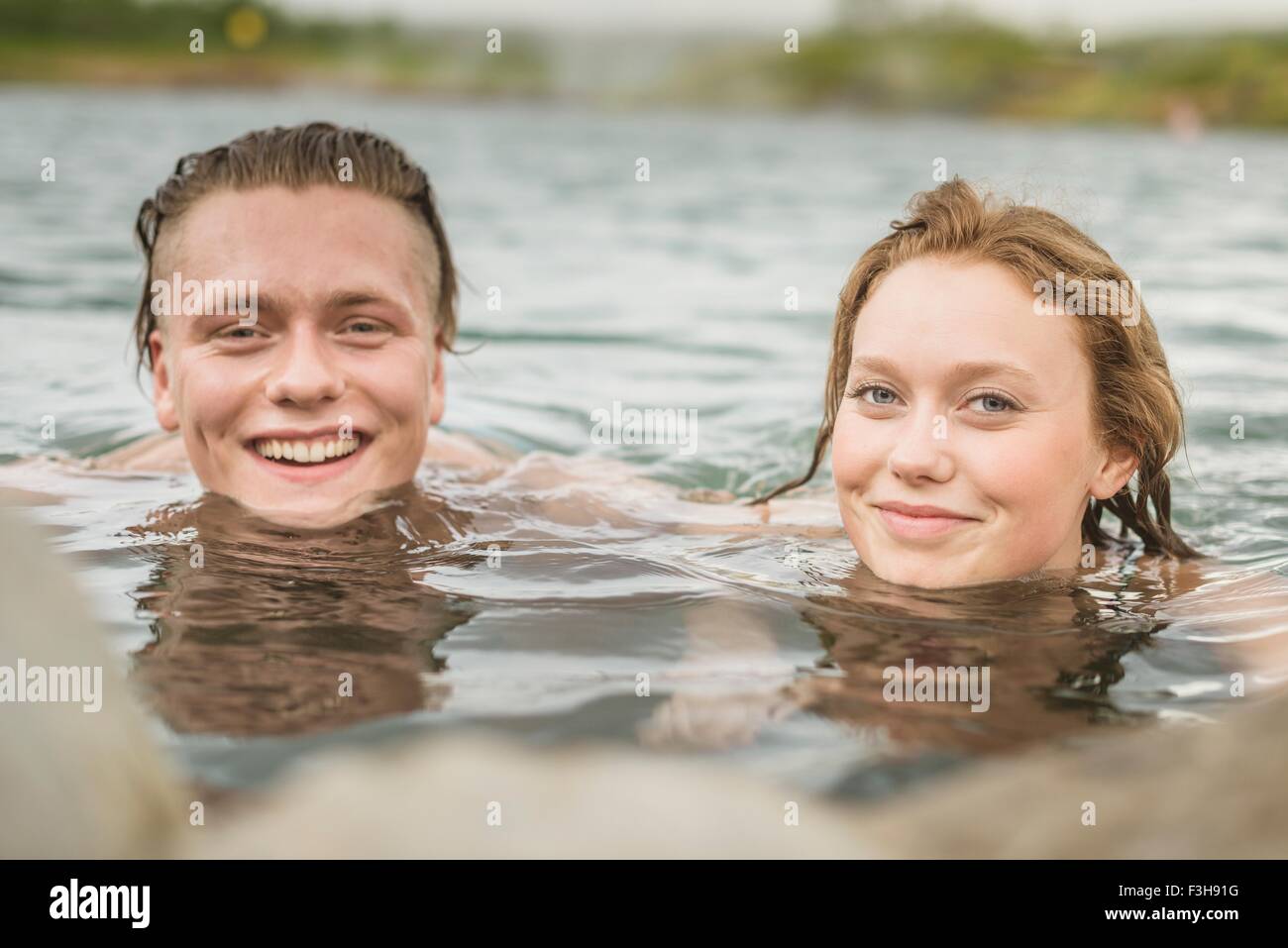 Portrait of young couple relaxing in Secret Lagoon hot spring (Gamla Laugin), Fludir, Iceland Stock Photo