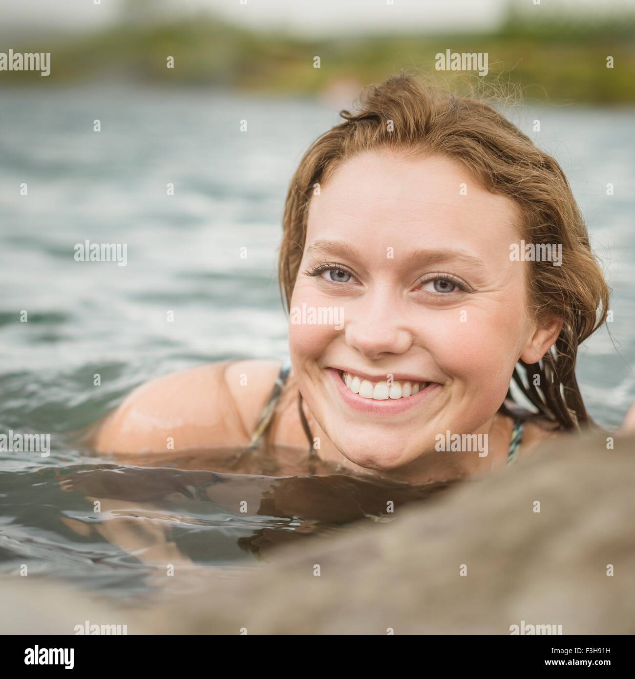 Close up portrait of young woman relaxing in Secret Lagoon hot spring (Gamla Laugin), Fludir, Iceland Stock Photo