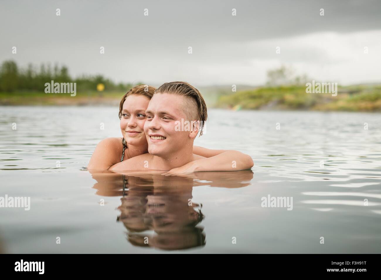 Young couple looking sideways from Secret Lagoon hot spring (Gamla Laugin), Fludir, Iceland Stock Photo