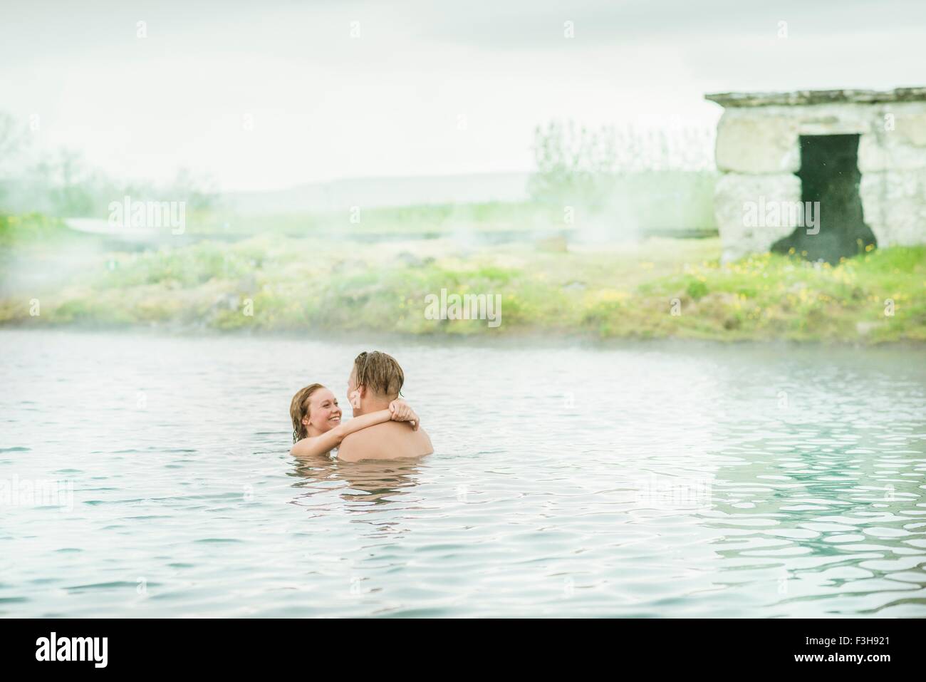 Romantic young couple relaxing in Secret Lagoon hot spring (Gamla Laugin), Fludir, Iceland Stock Photo