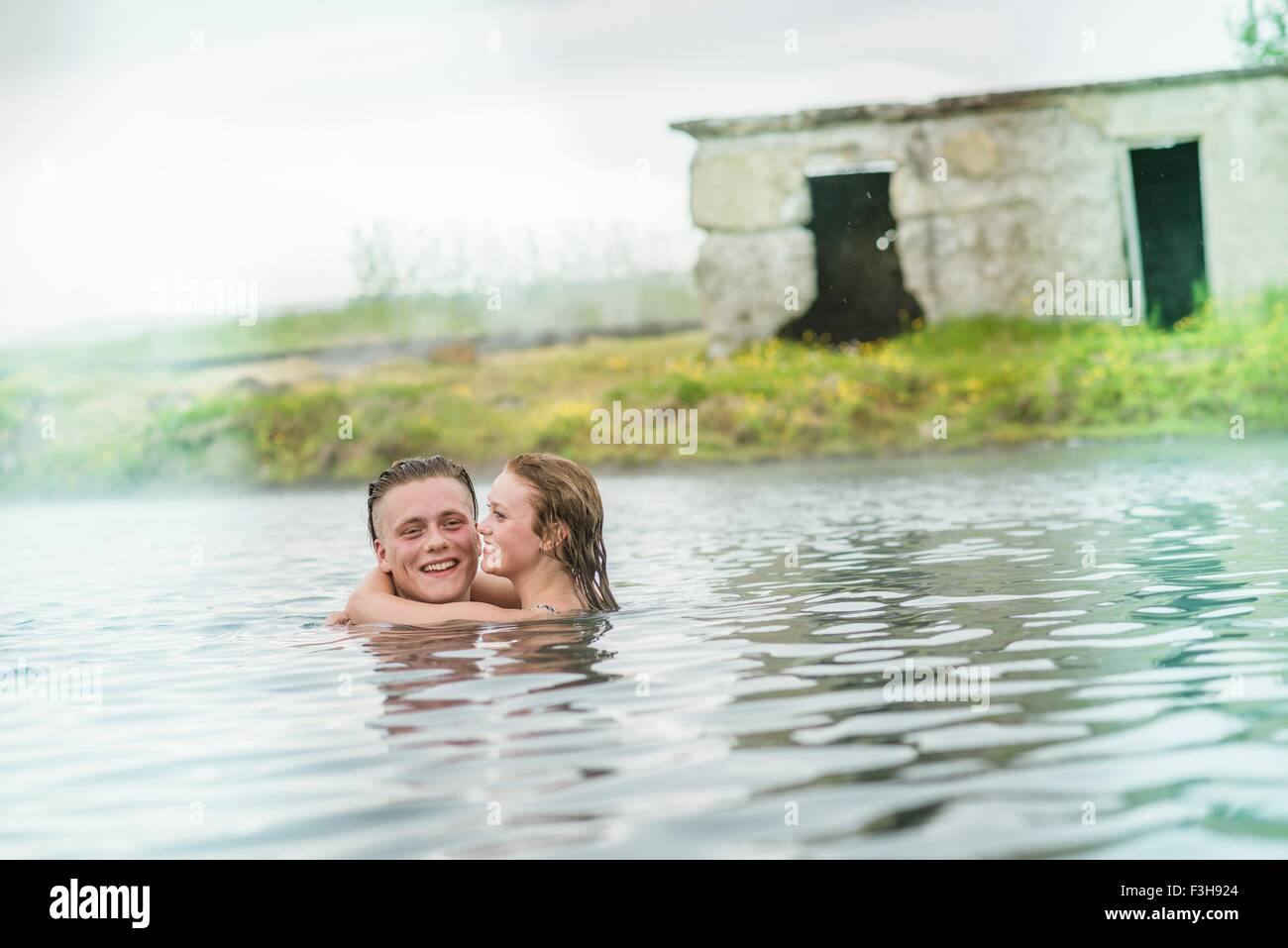 Young couple hugging in Secret Lagoon hot spring (Gamla Laugin), Fludir, Iceland Stock Photo