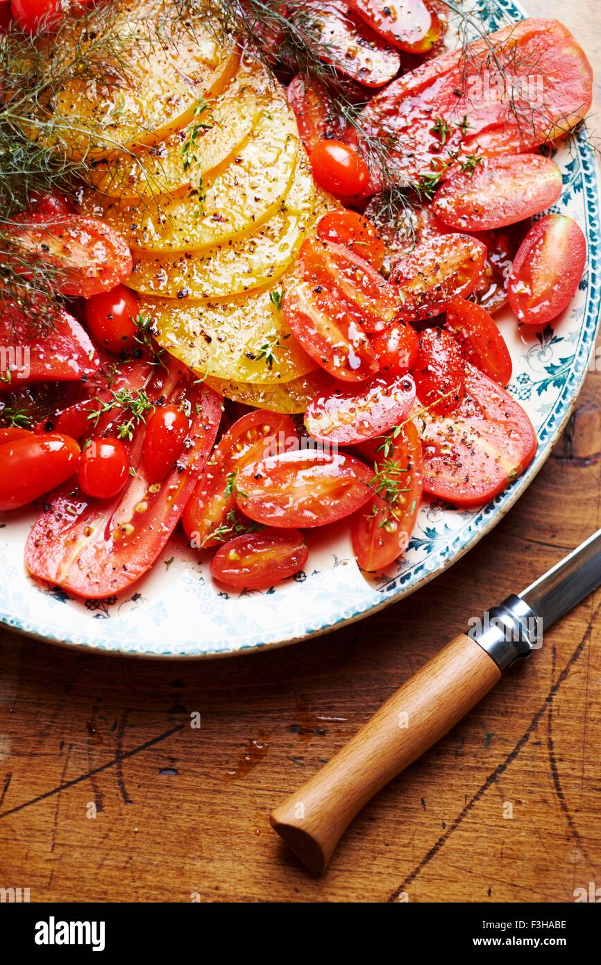 Selection of different types of tomatoes, sliced and seasoned, close-up Stock Photo