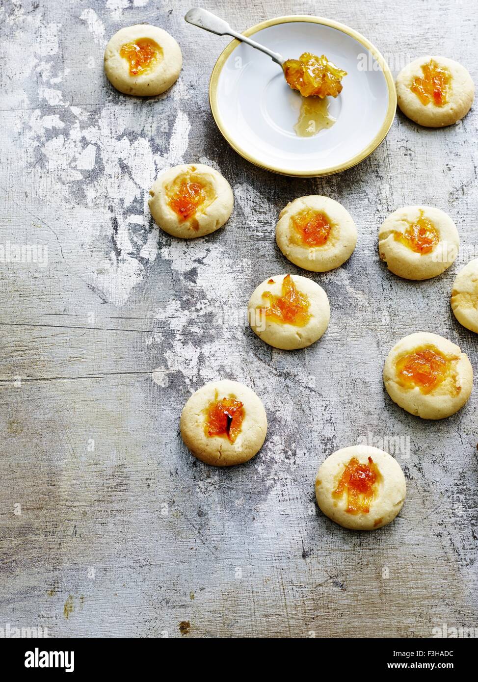 Overhead view of thumbprint cookies and spoonful of marmalade Stock Photo