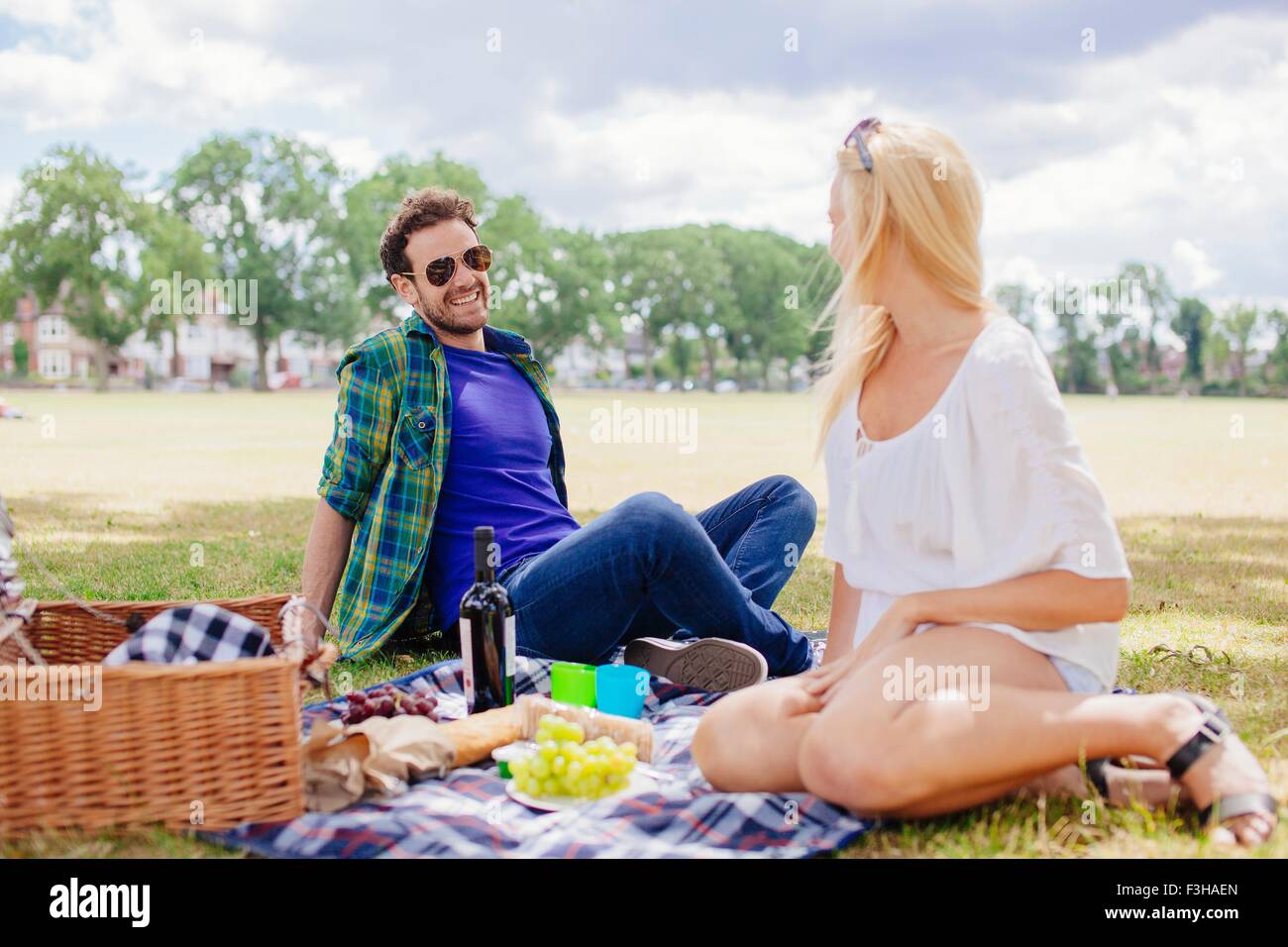 Couple sitting on blanket having a picnic Stock Photo