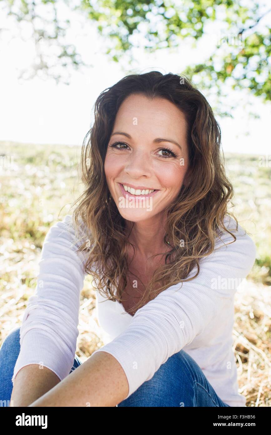 Portrait of mature woman sitting in park Stock Photo - Alamy