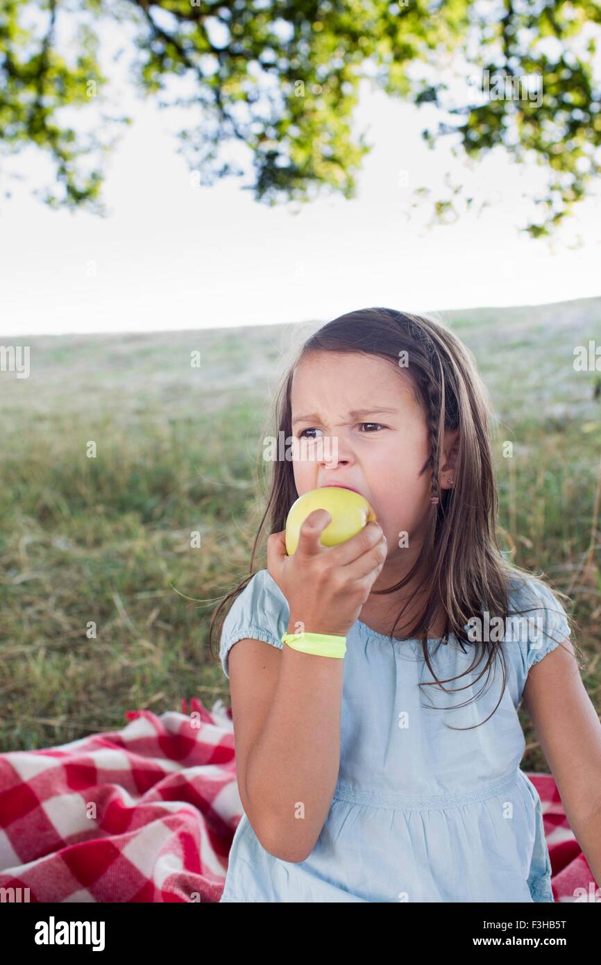 Girl eating green apple at park picnic Stock Photo Alamy