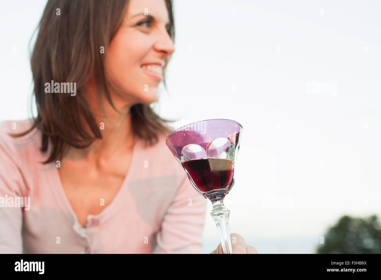 Mature woman drinking glass of red wine in park Stock Photo - Alamy