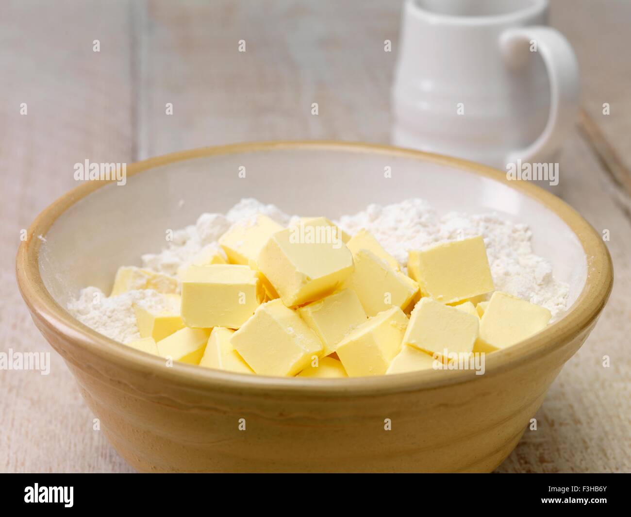 Still life of baking ingredients. Butter cubes and flour in mixing bow Stock Photo