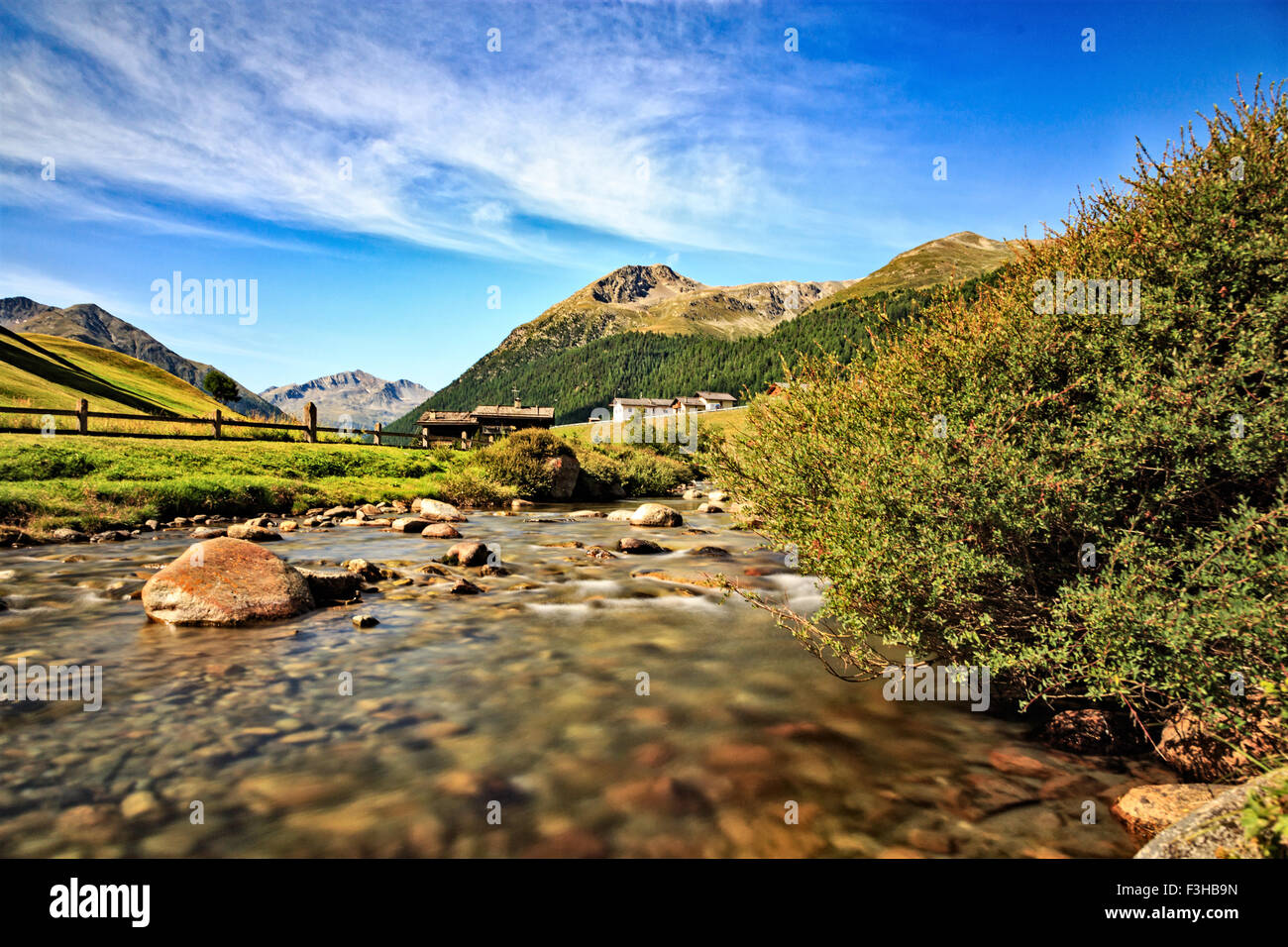 Low angle landscape view of a pretty little river flowing through a valley  in Livigno, Lombardy, Northern Italy with high alpine Stock Photo - Alamy